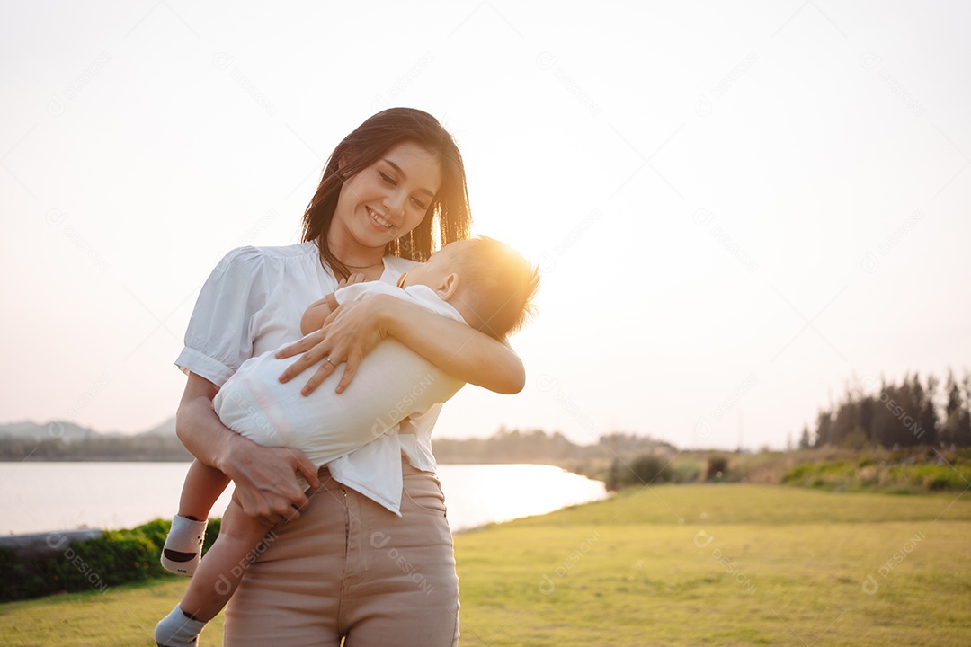 Mãe e filho juntos no pôr do sol do parque, família se divertindo juntos.