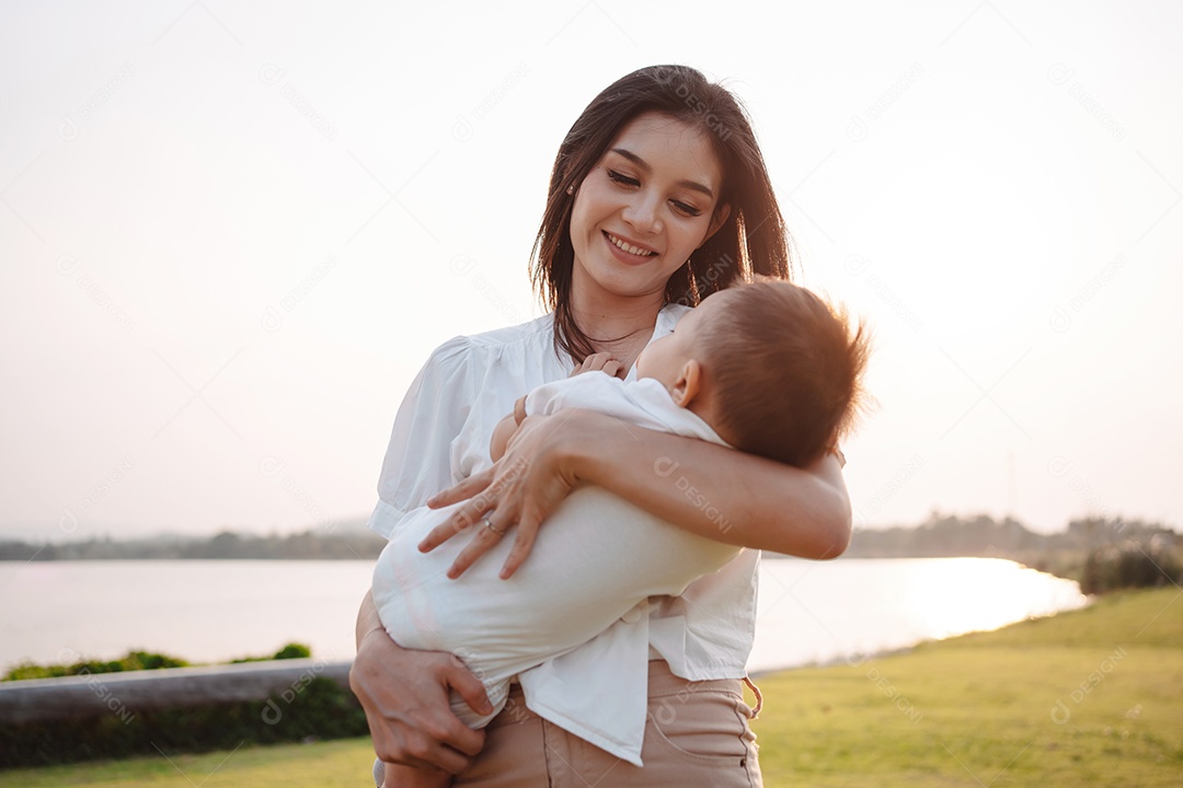 Mãe e filho juntos no pôr do sol do parque, família se divertindo juntos.