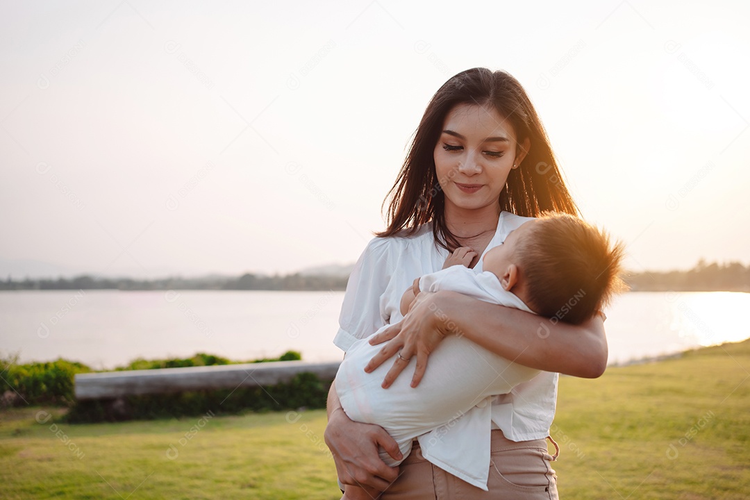 Mãe e filho juntos no pôr do sol do parque, família se divertindo juntos.