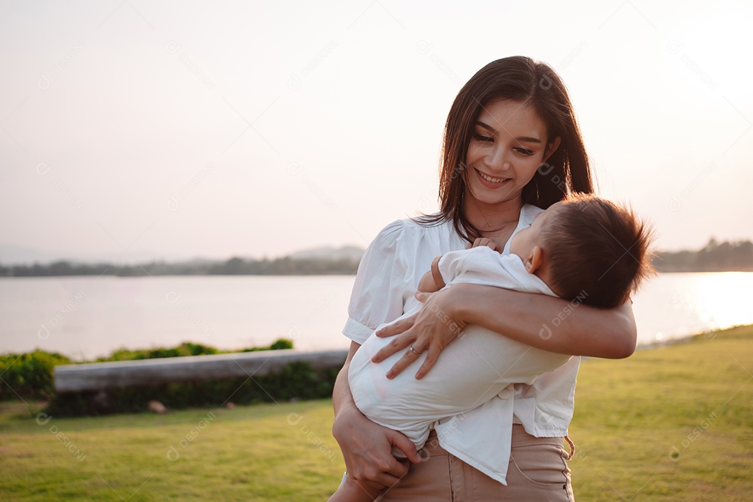 Mãe e filho juntos no pôr do sol do parque, família se divertindo juntos.