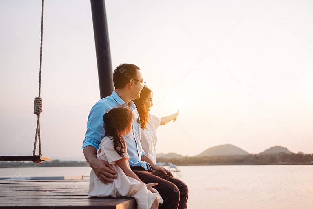 Família feliz curtindo com balanço no parque ao pôr do sol ao ar livre na natureza