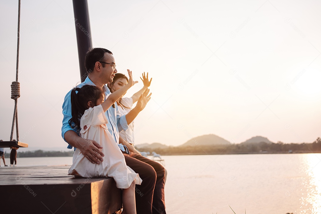 Família feliz curtindo com balanço no parque ao pôr do sol ao ar livre na natureza