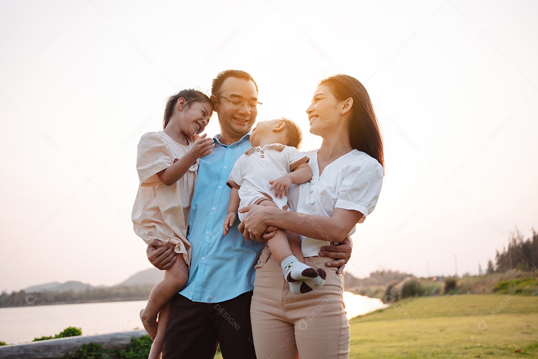 Família feliz na luz do sol do parque. família no fim de semana brincando juntos