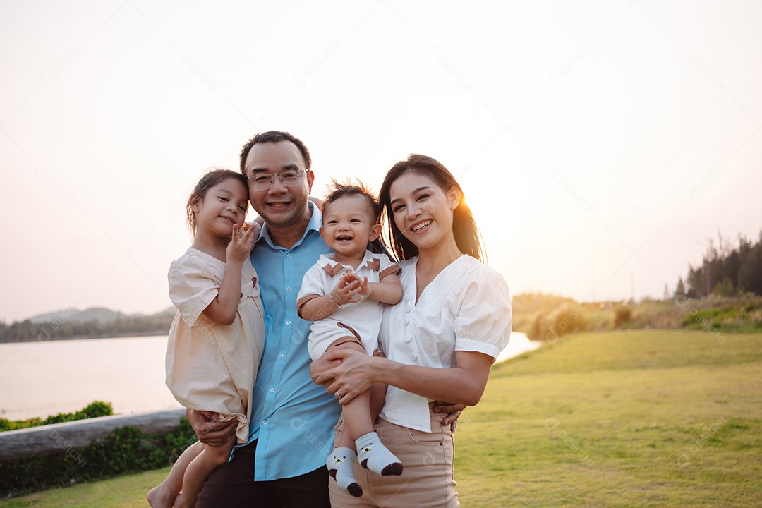 Família feliz na luz do sol do parque. família no fim de semana brincando juntos