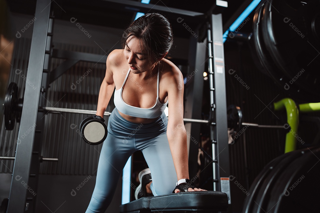 Mulheres malhando com pesos de treinamento levantando halteres no ginásio de fitness.