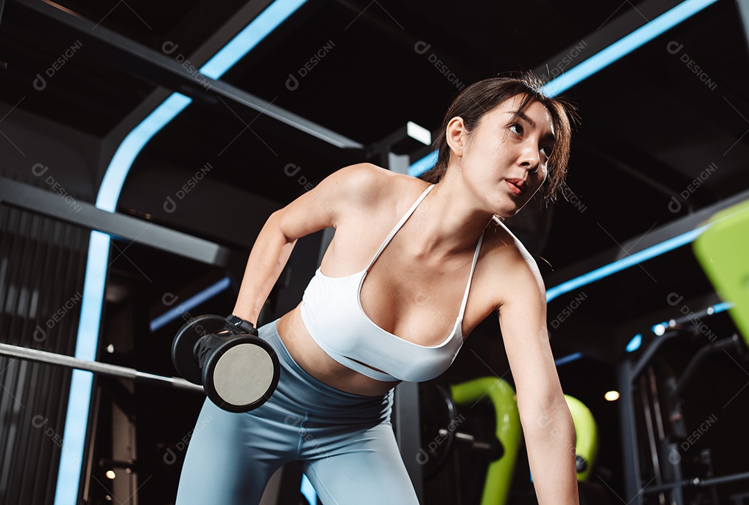 Mulheres malhando com pesos de treinamento levantando halteres no ginásio de fitness.