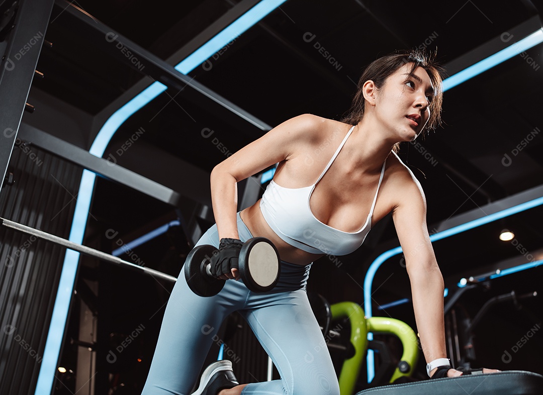 Mulheres malhando com pesos de treinamento levantando halteres no ginásio de fitness.