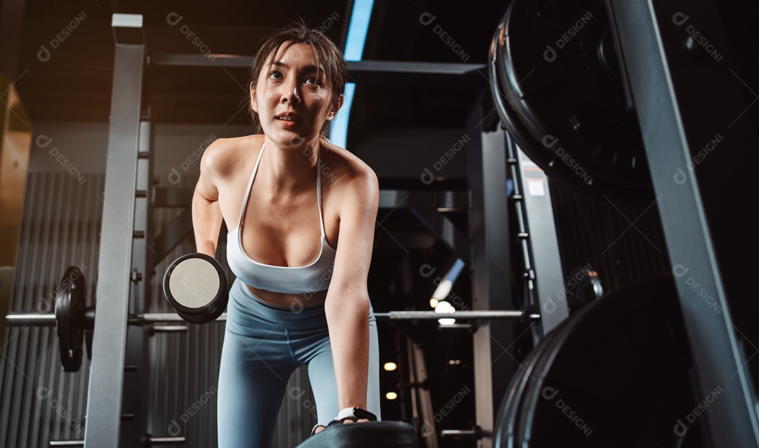 Mulheres malhando com pesos de treinamento levantando halteres no ginásio de fitness.