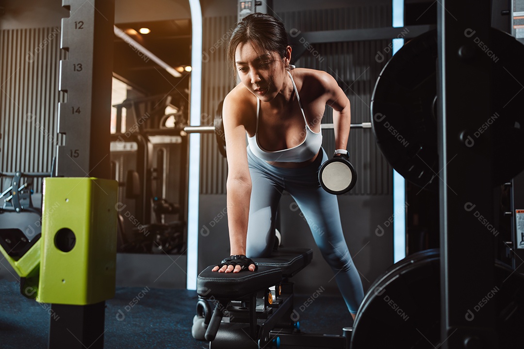 Mulheres malhando com pesos de treinamento levantando halteres no ginásio de fitness.