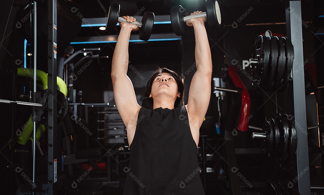 Macho malhando fisiculturista com pesos de halteres no fisiculturista gym.man fazendo exercícios com halteres.