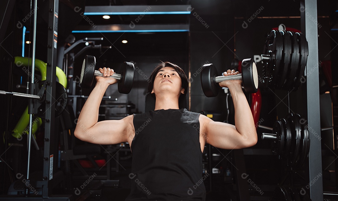Macho malhando fisiculturista com pesos de halteres no fisiculturista gym.man fazendo exercícios com halteres.