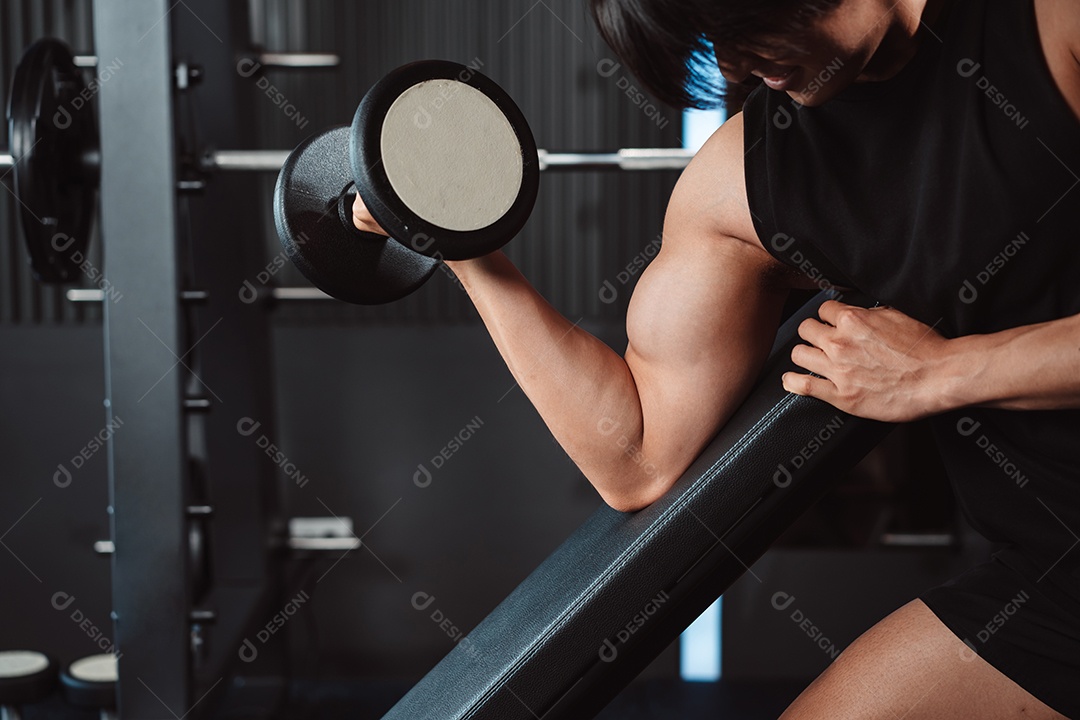Macho malhando fisiculturista com pesos de halteres no fisiculturista