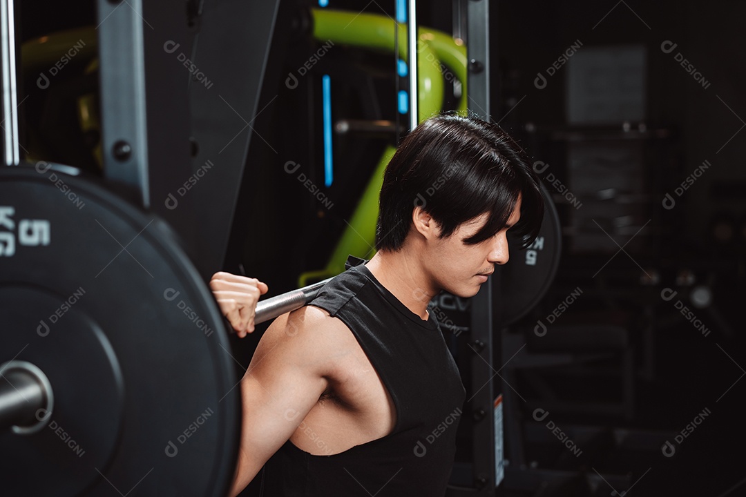 Homem malhando fisiculturista com pesos de barra no ginásio. fisiculturista fazendo exercícios com barra.
