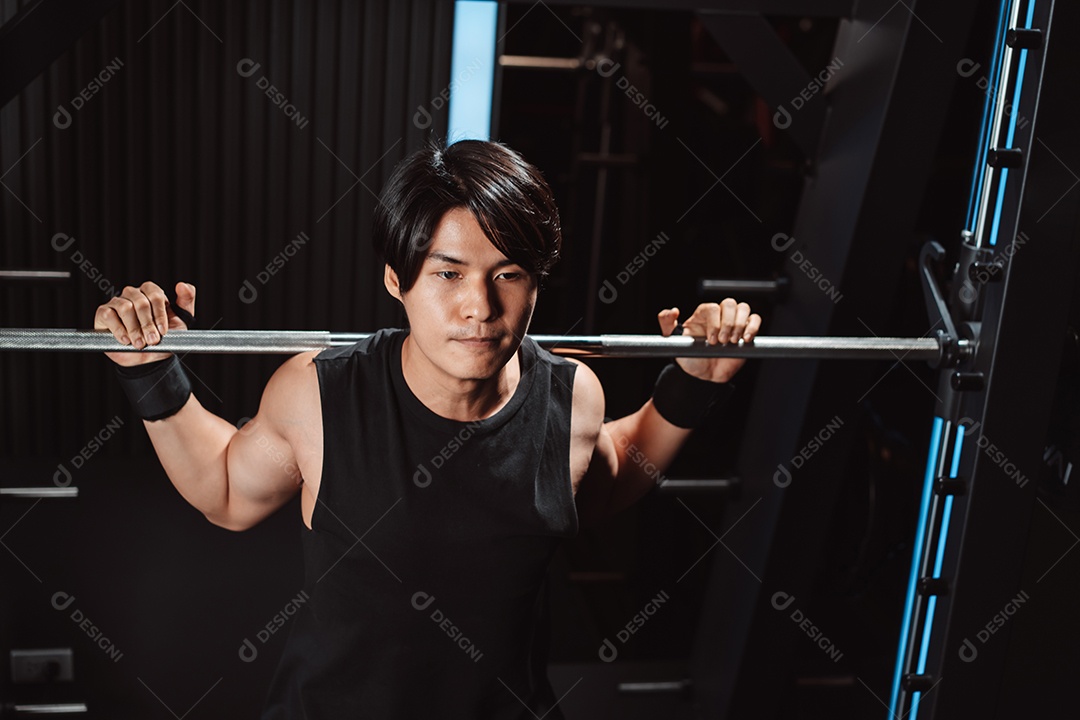 Homem malhando fisiculturista com pesos de barra no ginásio. fisiculturista fazendo exercícios com barra.