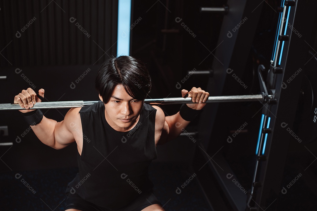 Homem malhando fisiculturista com pesos de barra no ginásio. fisiculturista fazendo exercícios com barra.