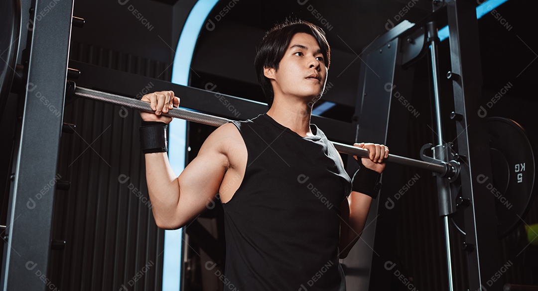 Homem malhando fisiculturista com pesos de barra no ginásio. fisiculturista fazendo exercícios com barra.