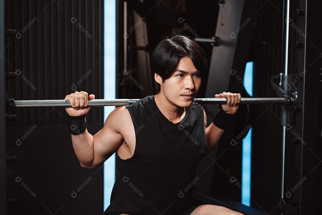 Homem malhando fisiculturista com pesos de barra no ginásio. fisiculturista fazendo exercícios com barra.