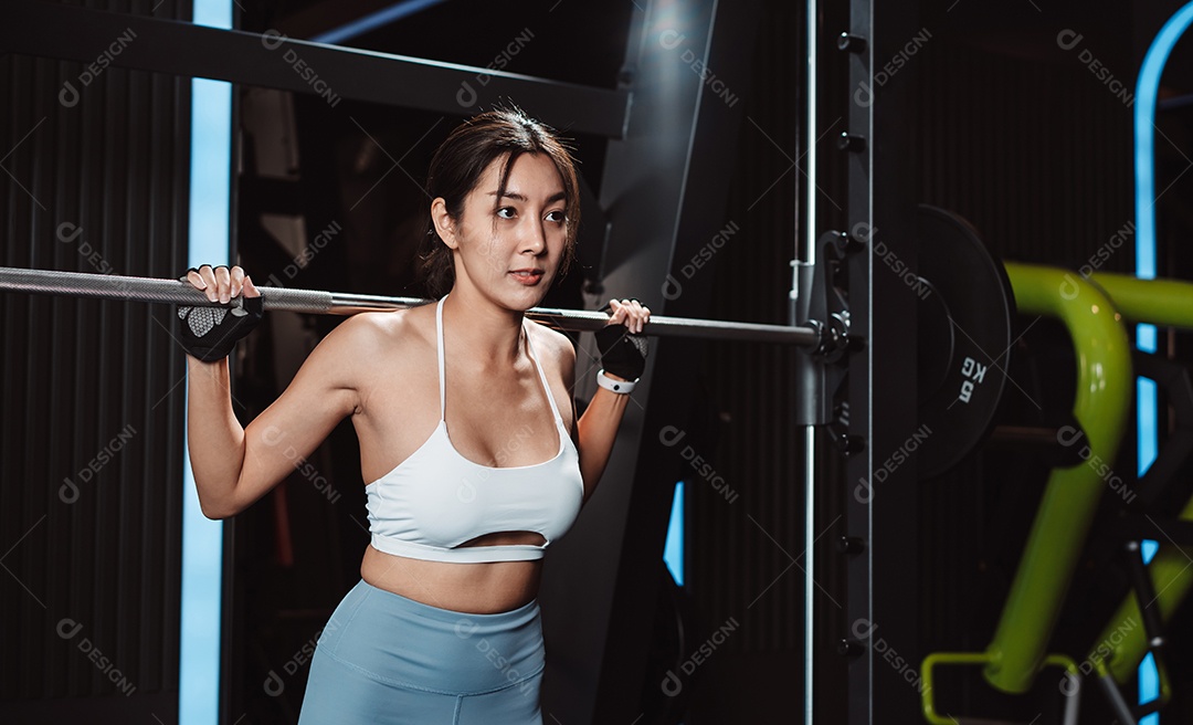 Mulher malhando fisiculturista com pesos de barra na academia.