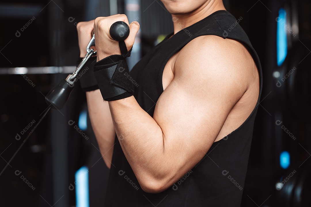 Homem malhando com máquina de treinamento de pesos levantando halteres no ginásio de fitness.