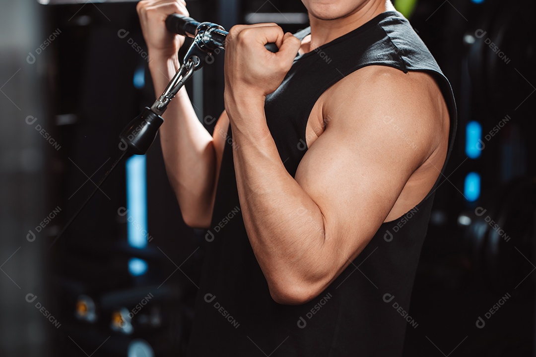 Homem malhando com máquina de treinamento de pesos levantando halteres no ginásio de fitness.