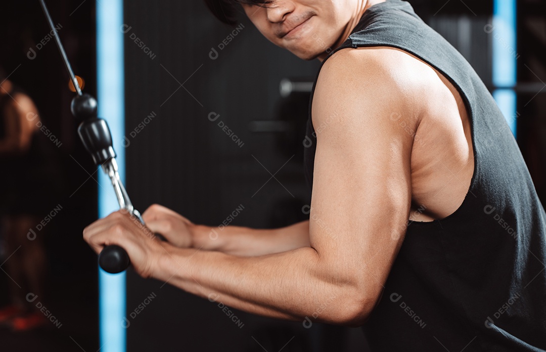 Homem malhando com máquina de treinamento de pesos levantando halteres no ginásio de fitness.