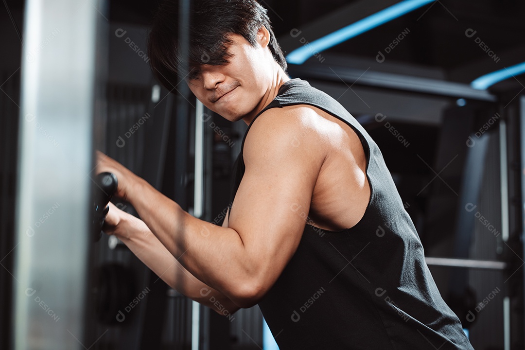 Homem malhando com máquina de treinamento de pesos levantando halteres no ginásio de fitness.