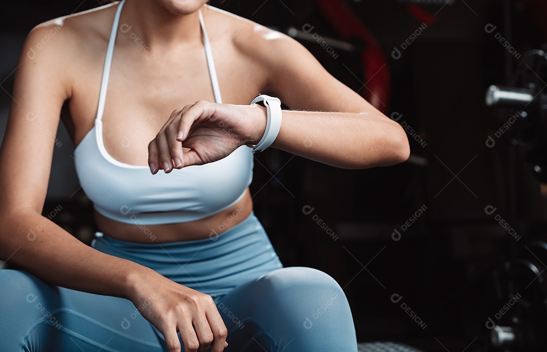 Mulher malhando fisiculturista com pesos de halteres na Academia.