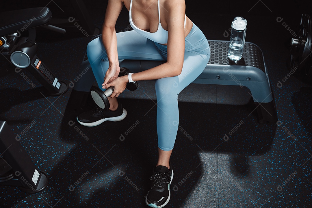 A mulher verificando o tempo e usando o smartphone no exercício