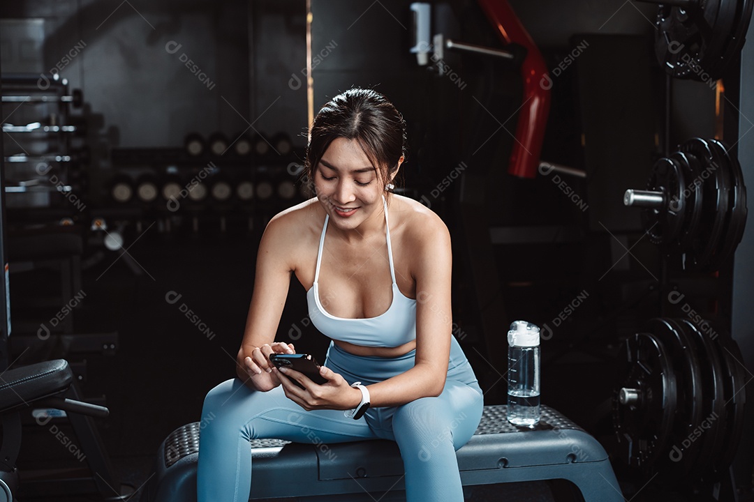 A mulher verificando o tempo e usando o smartphone no exercício