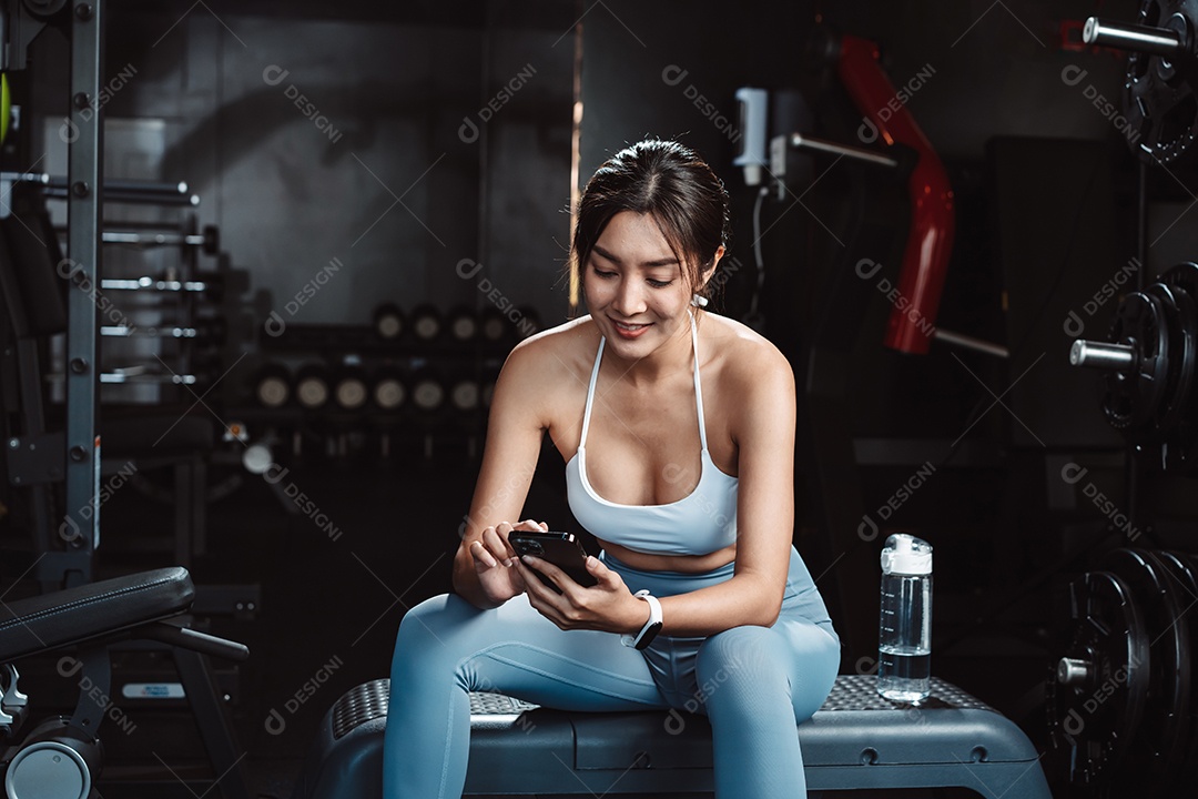 A mulher verificando o tempo e usando o smartphone no exercício