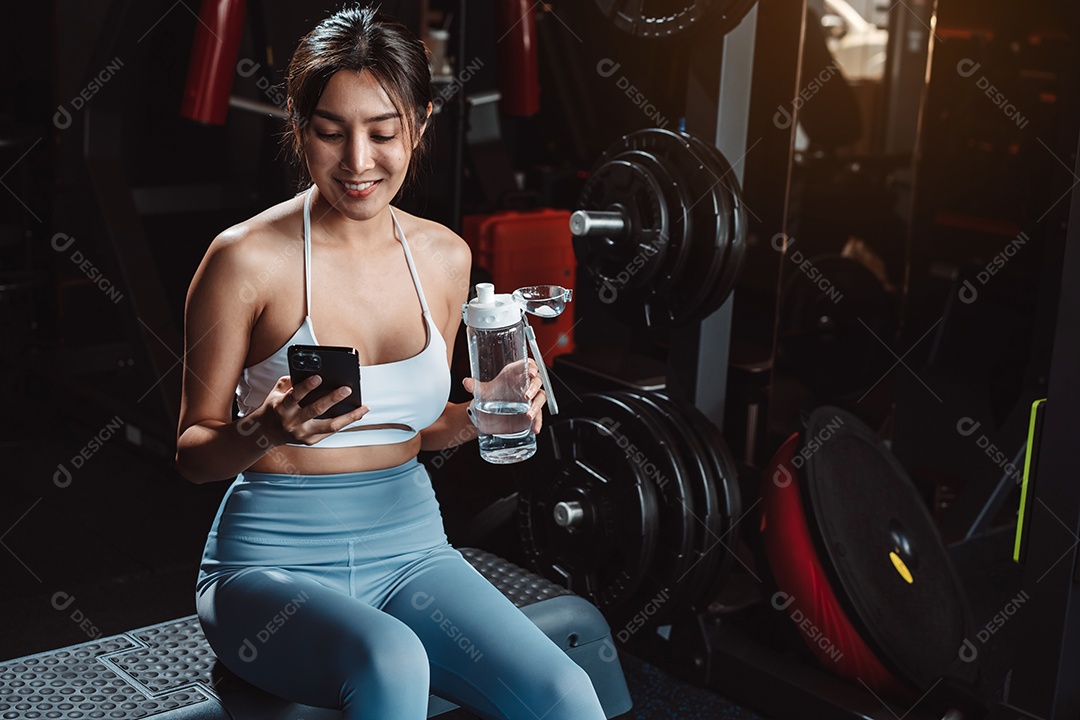 A mulher verificando o tempo e usando o smartphone no treino