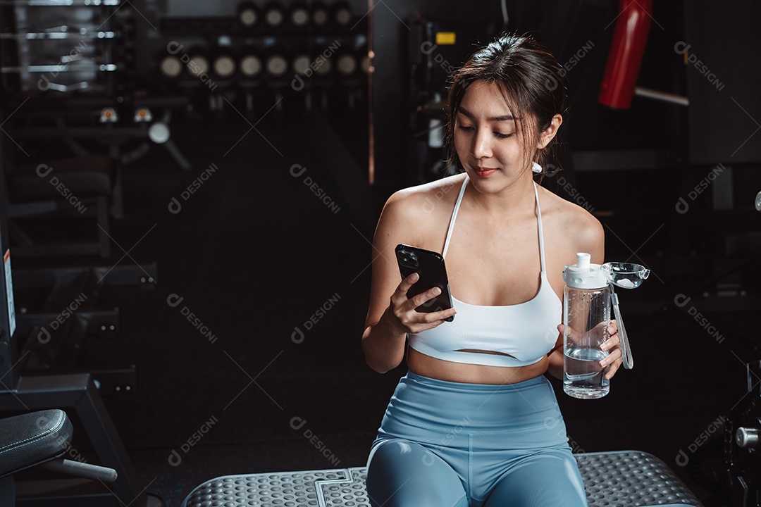 A mulher verificando o tempo e usando o smartphone no treino