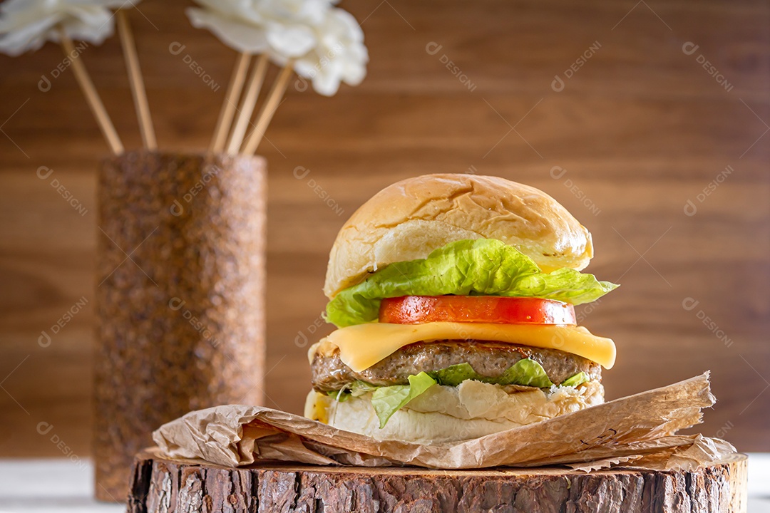 Delicioso hambúrguer com queijo cheddar sobre tronco de madeira