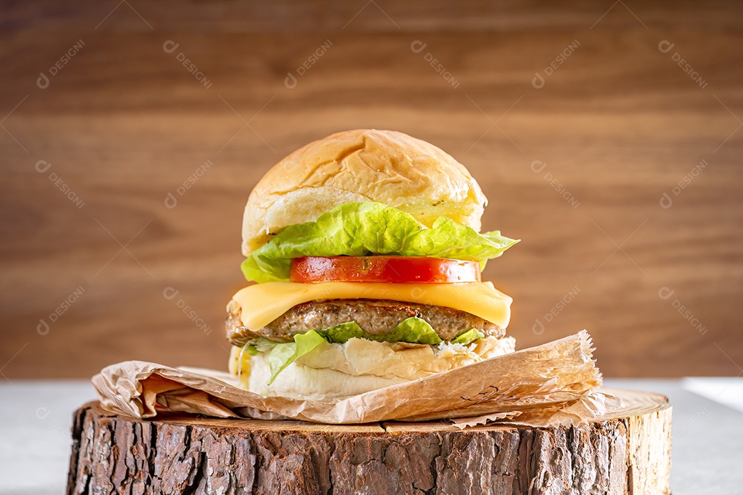 Delicioso hambúrguer com queijo cheddar sobre tronco de madeira