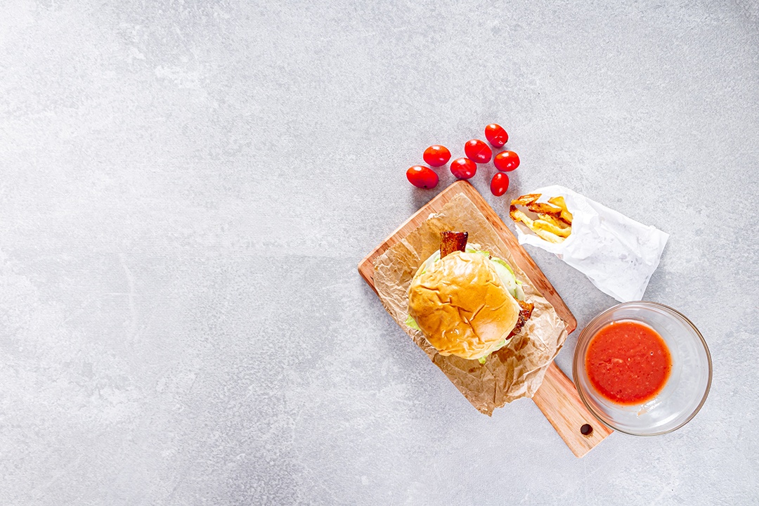 Delicioso hambúrguer com queijo cheddar sobre tábua de madeira