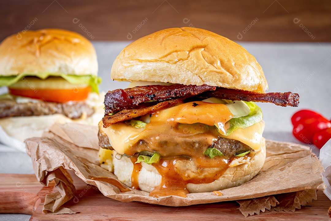 Delicioso hambúrguer com queijo cheddar sobre tábua de madeira