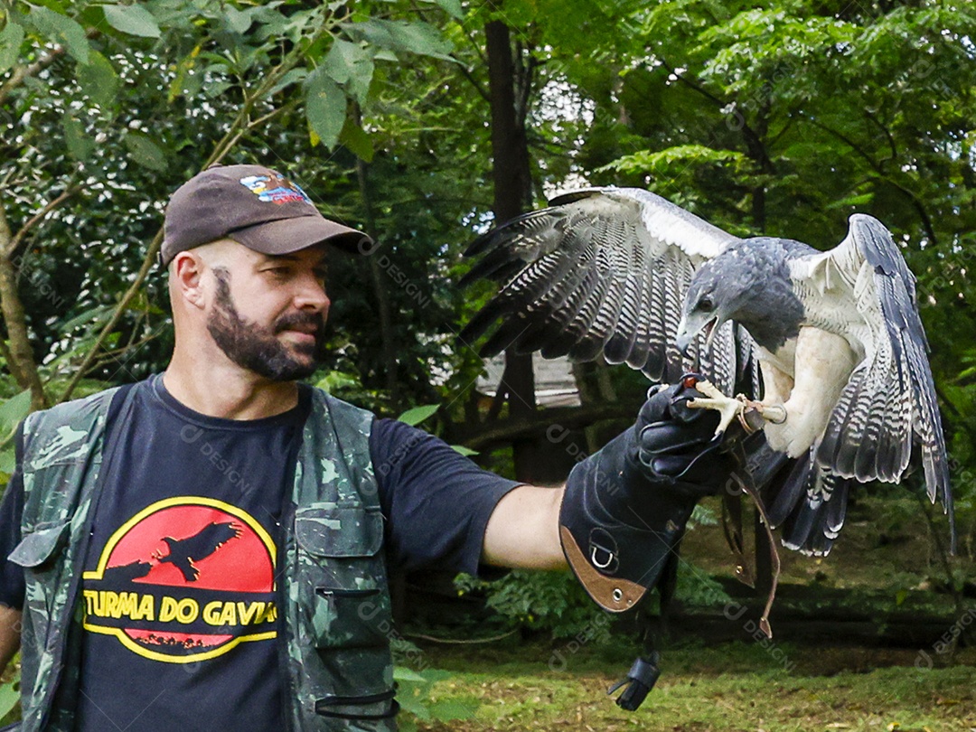 Homem jovem sobre campo verde com seu animal de estimação águia