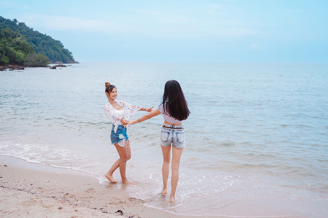 Felizes duas amigas curtindo juntas na praia.