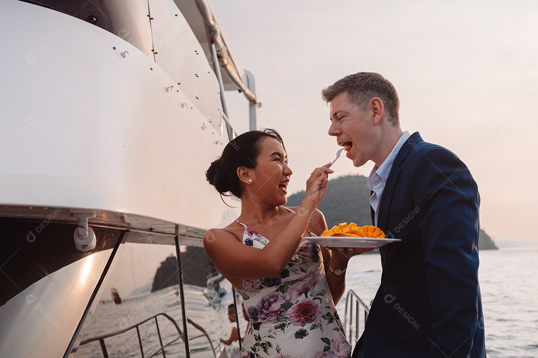 Casal romântico abraçando juntos, homem e mulher desfrutando de lua de mel em iate de luxo.