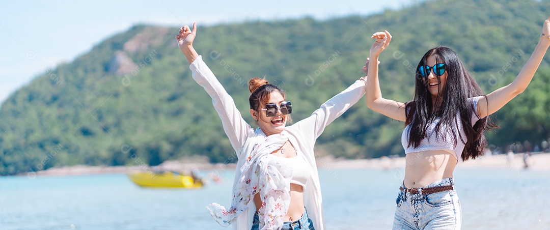 Felizes duas amigas curtindo juntas na praia.