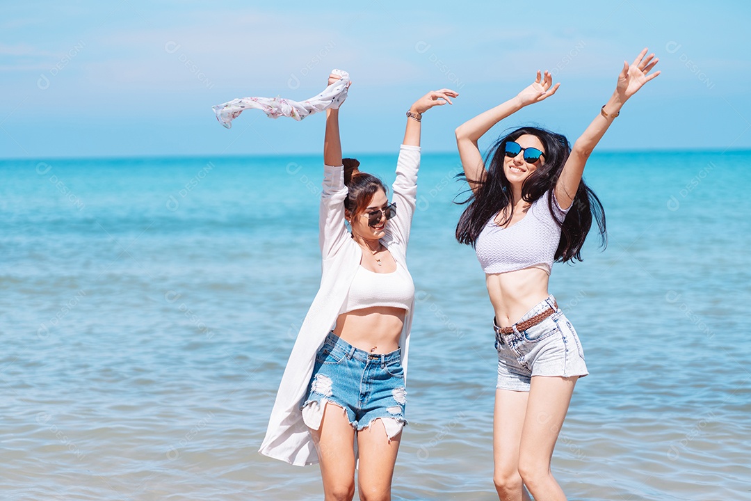 Felizes duas amigas curtindo juntas na praia.