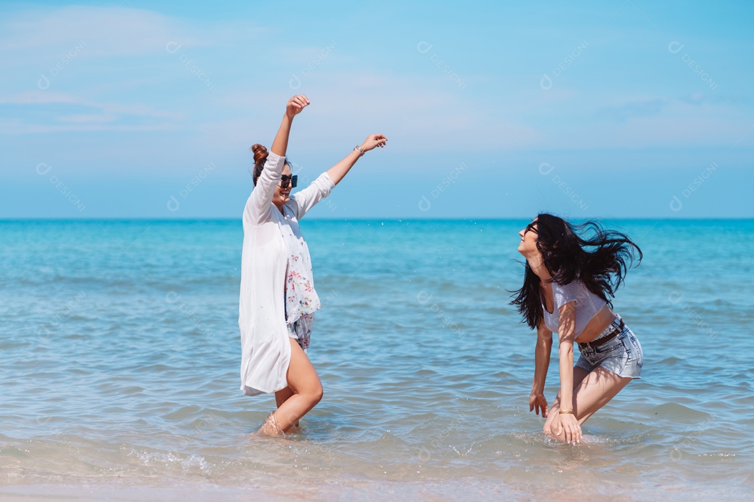 Felizes duas amigas curtindo juntas na praia.