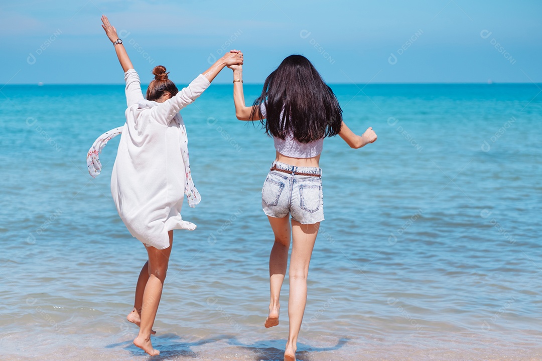 Felizes duas amigas curtindo juntas na praia.