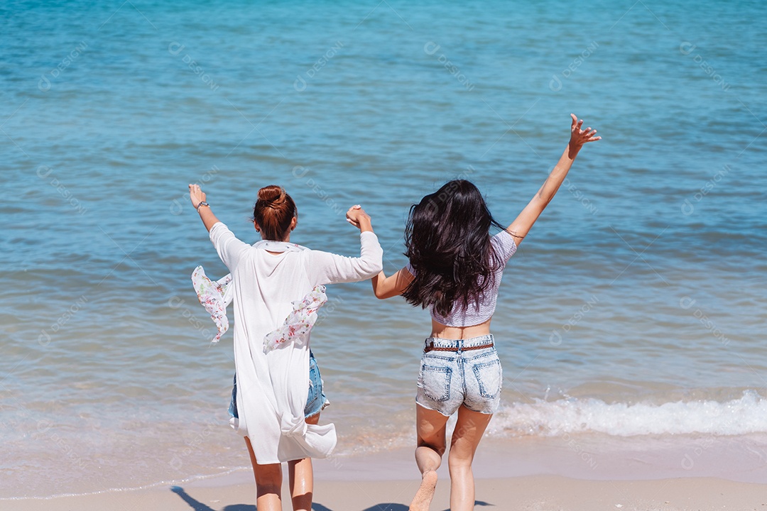 Felizes duas amigas curtindo juntas na praia.