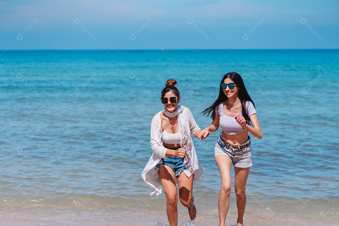 Felizes duas amigas curtindo juntas na praia.