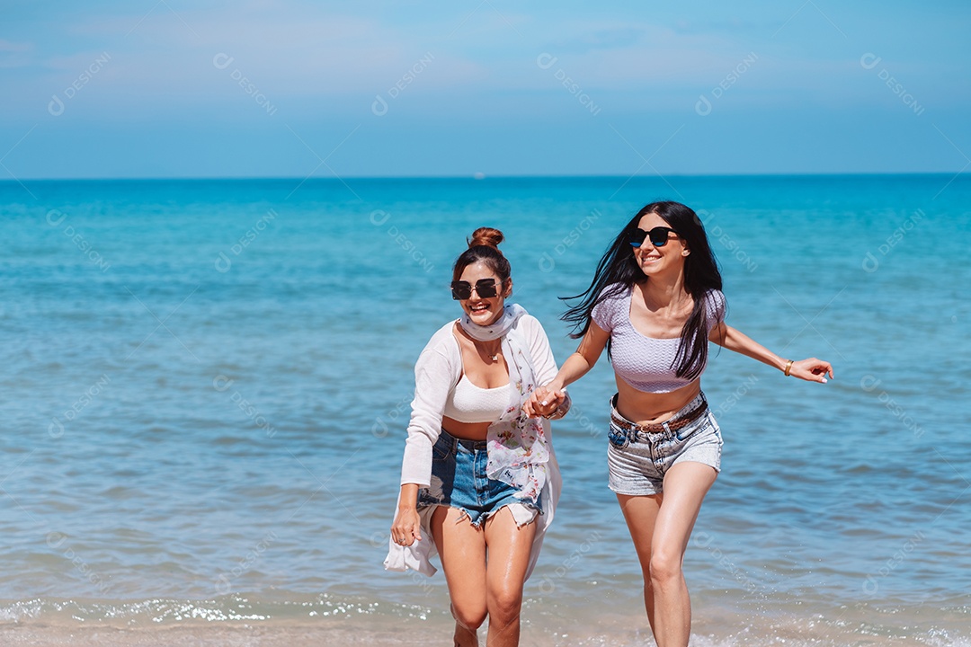 Felizes duas amigas curtindo juntas na praia.