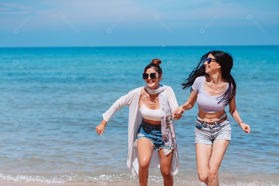 Felizes duas amigas curtindo juntas na praia.