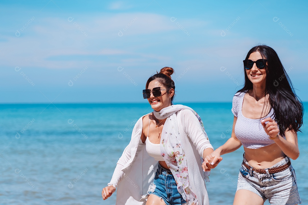 Felizes duas amigas curtindo juntas na praia.