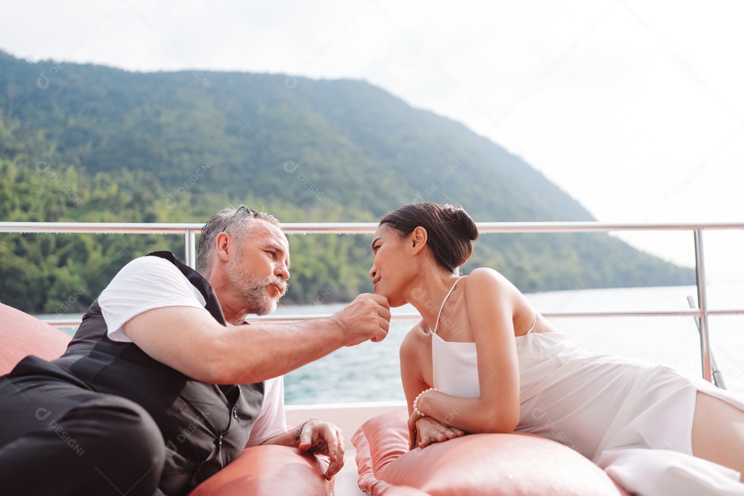 Casal sênior feliz e apaixonado no iate flutuando no mar ao pôr do sol