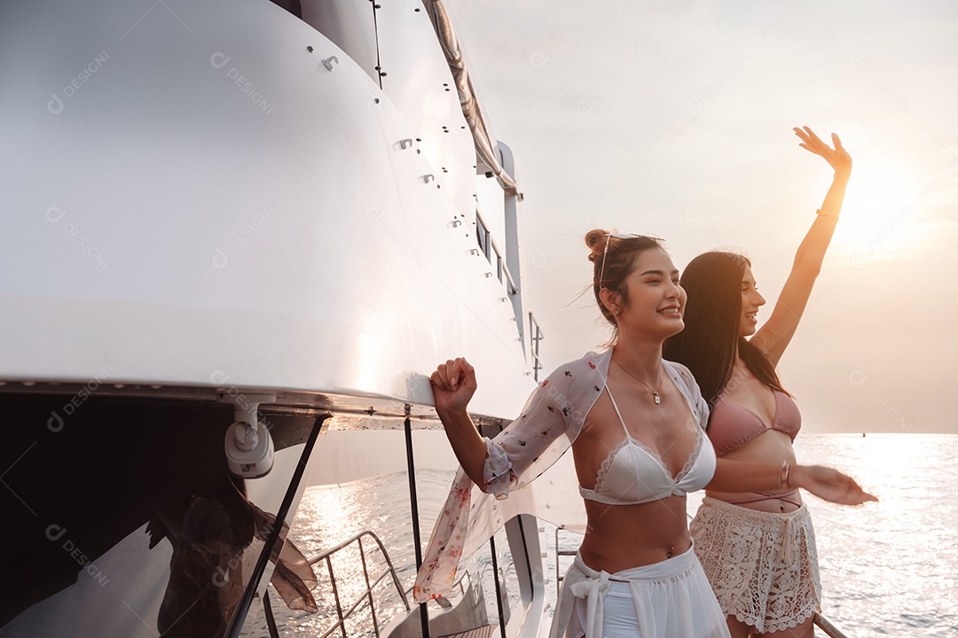 Duas belas amigas no iate de luxo. Se divertindo juntos e aproveitando o sol